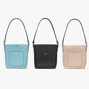 Three shoulder bags in light blue, black, and beige, with front pockets and brand logos.