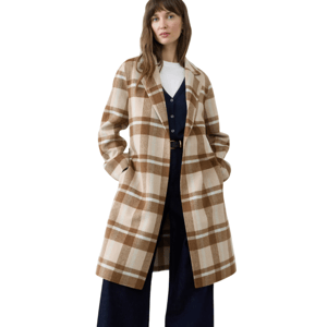 A woman models a long, plaid coat in brown and beige with front pockets, layered over a white top and a dark vest. She's also wearing wide-leg dark pants and black shoes.