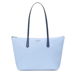 Light blue tote bag with dark handles, featuring a zippered top and a minimalist design.