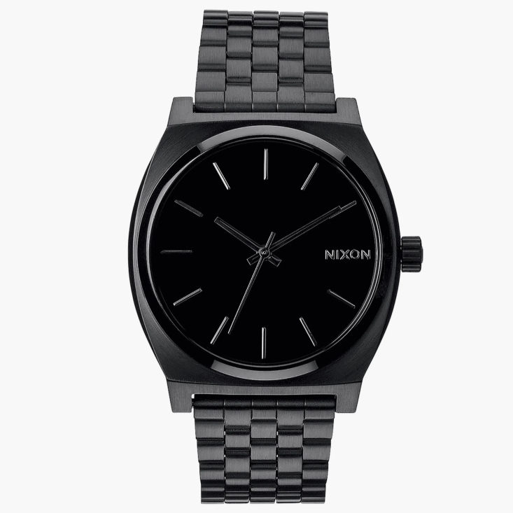 A black Nixon wristwatch with a minimalist design, featuring a black stainless steel band and a simple black analog dial with silver hour markers and hands.