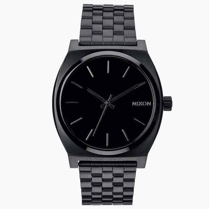 A black Nixon wristwatch with a minimalist design, featuring a black stainless steel band and a simple black analog dial with silver hour markers and hands.
