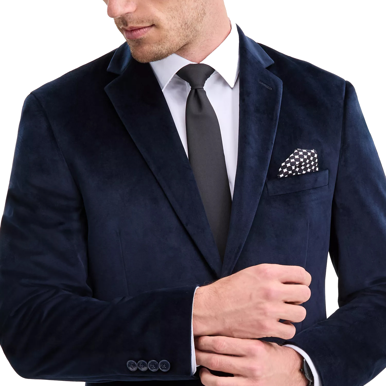 A man is wearing a dark blue velvet suit jacket with a white shirt, gray tie, and a black and white patterned pocket square.