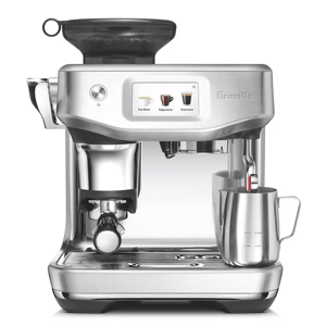 A silver Breville espresso machine with a digital display, featuring options for Flat White, Cappuccino, and Americano. It includes a milk frother and a stainless steel jug.