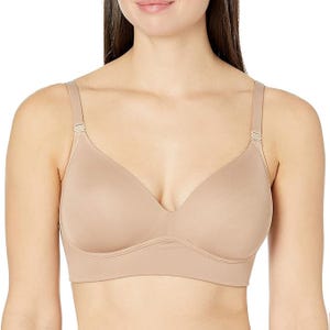 A woman is wearing a seamless, nude-colored, wireless bra with adjustable straps. The bra offers a smooth and comfortable fit.