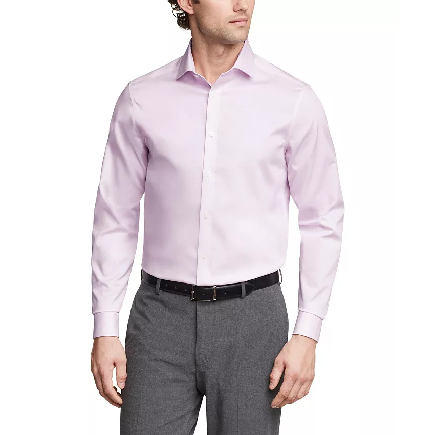 A man is wearing a light pink Calvin Klein dress shirt with long sleeves and a classic collar, paired with gray trousers and a black belt.
