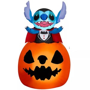 Inflatable Halloween decoration featuring a character dressed as a vampire, sitting inside a large, grinning jack-o'-lantern.