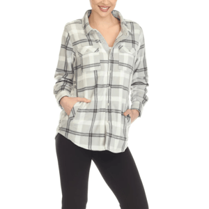 A person is wearing a plaid long-sleeve shirt with front pockets and black pants, standing with hands in pockets.