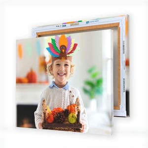 Two stacked canvas prints featuring a child wearing a colorful turkey hat, holding autumn-themed pumpkins and pinecones. The product emphasizes customized canvases with complimentary shipping.