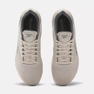 A pair of beige Reebok sneakers facing towards the viewer.