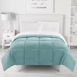 A neatly made bed features a light teal checkered comforter with white sheets, a white headboard, a white nightstand with a lamp on the left, and shelves on the wall to the right.