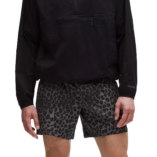 A person is wearing black shorts with a leopard print pattern and a black long-sleeved top with a front zipper pocket.