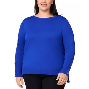 A plus-size woman is wearing a bright blue long-sleeve sweater with ribbed cuffs and button details on the sleeves, paired with black pants.