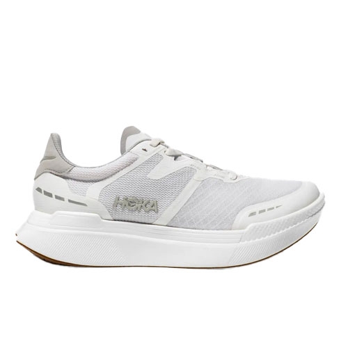 Hoka Transport X Shoes feature a sleek, all-white design with a breathable mesh upper, cushioned sole, and subtle branding on the side. They are designed for comfort and style, suitable for running or casual wear.
