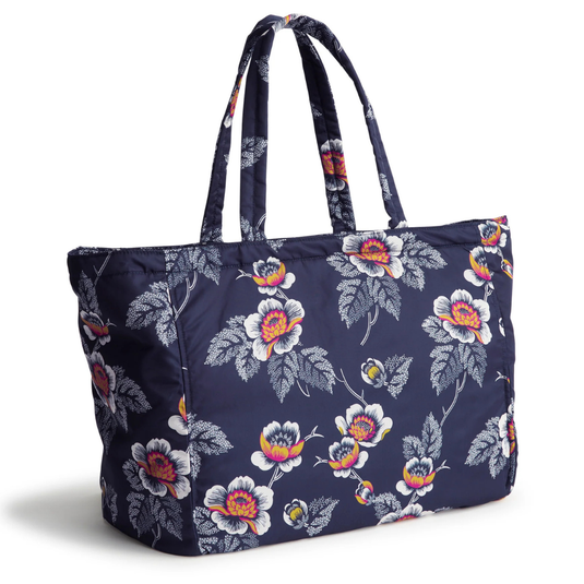 A floral-patterned tote bag with navy blue background and white, red, and yellow flowers, featuring two handles for carrying.
