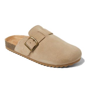 A beige suede clog with a large brass buckle and a cork sole features a comfortable slip-on design.