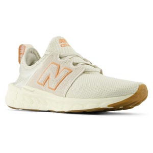 A pair of New Balance sneakers in a light beige color with the brand's 'N' logo on the side.