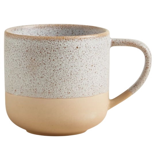 A ceramic mug with a speckled top and smooth beige bottom, featuring a large handle and rounded shape.