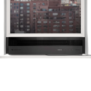 A sleek, black window-mounted air conditioner fitting into a raised window, with a view of urban buildings in the background.