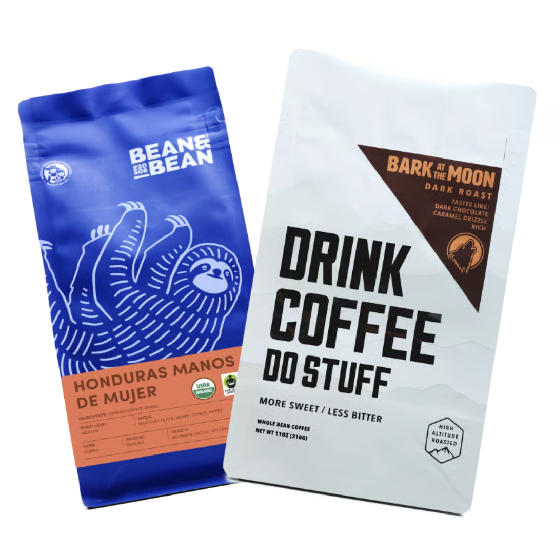 Two coffee bags: one from Bean & Bean featuring Honduras Manos de Mujer with notes of milk chocolate and honey, and another from Drink Coffee Do Stuff, a dark roast called Bark at the Moon with flavors of dark chocolate and caramel drizzle.