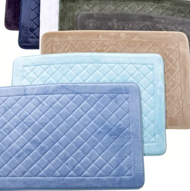 A collection of rectangular bath mats in various colors including blue, light blue, tan, green, and white, with quilted patterns.
