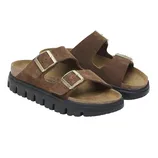 Brown suede sandals with two adjustable straps and gold buckles, featuring a thick black sole with a rugged tread.
