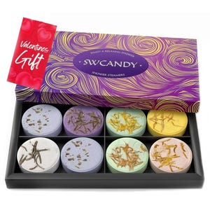 8-piece set of SWCANDY aromatherapy shower steamers in a rectangular box. Each steamer is a colored disk with natural botanical decorations, designed for a relaxing shower experience. Box packaging is purple with swirling gold patterns and labeled as a Valentine's gift.
