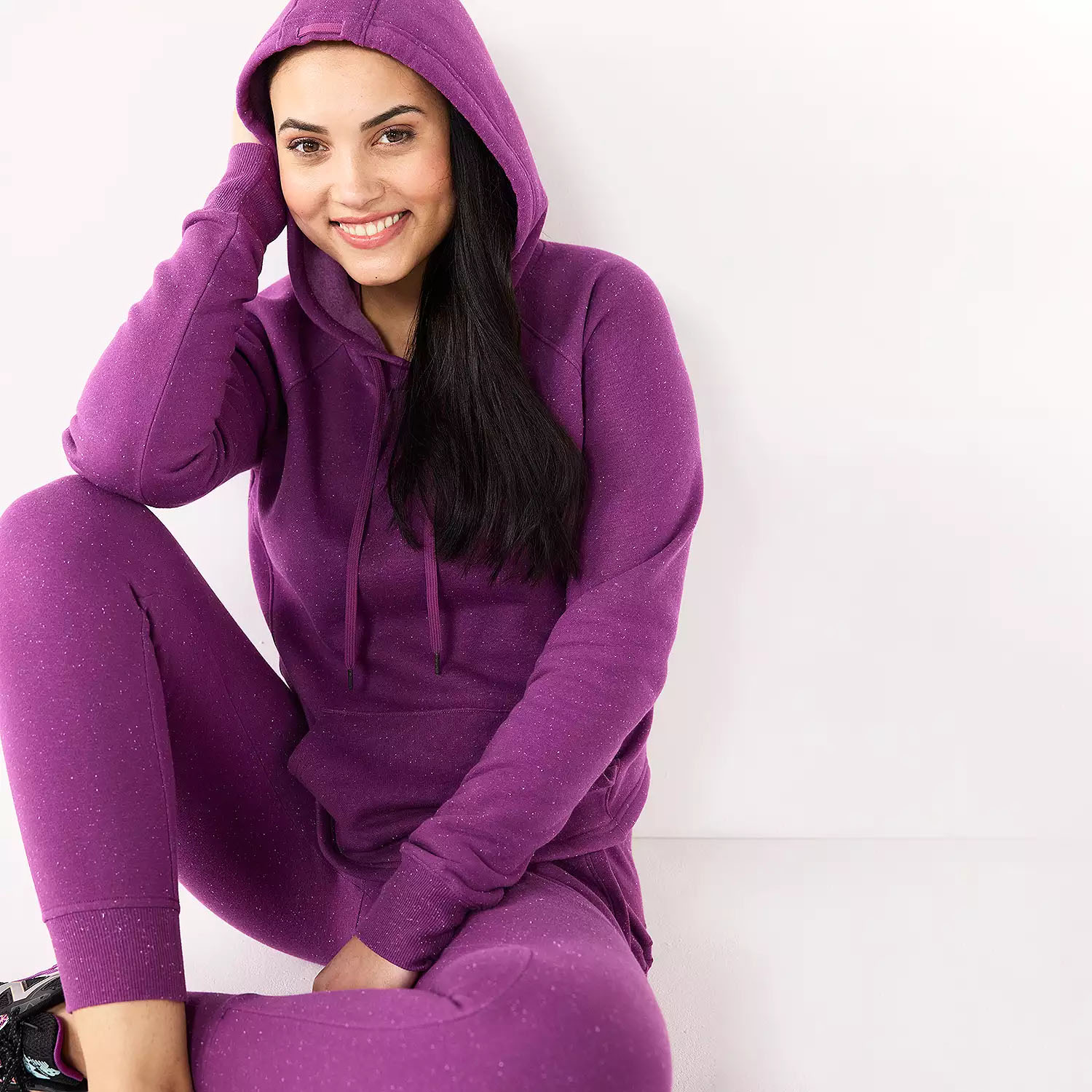 Woman wearing a purple hoodie and matching leggings.