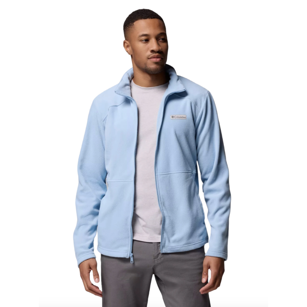 A man is wearing a light blue Columbia fleece jacket over a gray shirt, paired with gray pants.