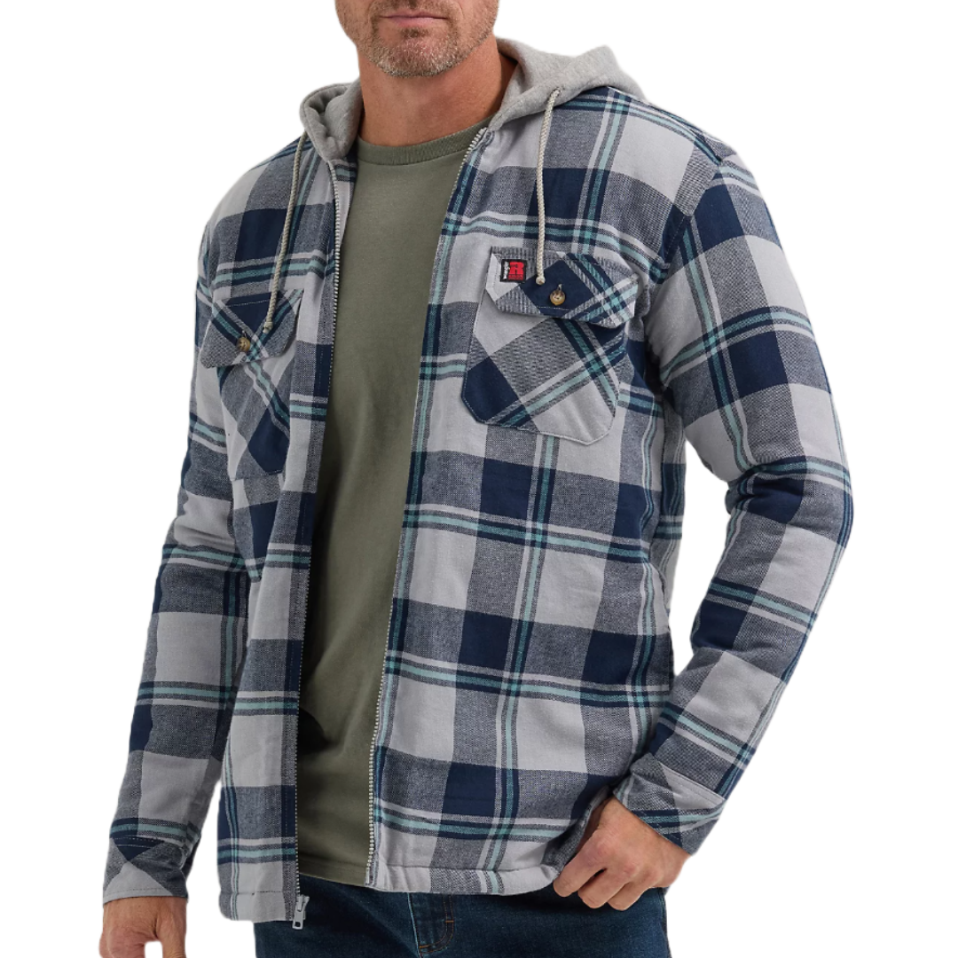 A man is wearing a plaid zip-up hoodie with two chest pockets and a drawstring hood over a green t-shirt.