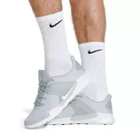 White crew-length socks displaying the Nike swoosh logo, designed with ribbed cuffs for a snug fit and cushioning for comfort.