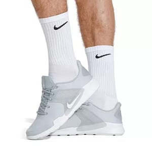 White crew-length socks displaying the Nike swoosh logo, designed with ribbed cuffs for a snug fit and cushioning for comfort.