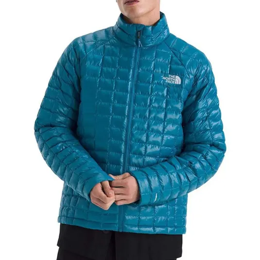 A blue, quilted jacket from The North Face with a high collar and zip closure.