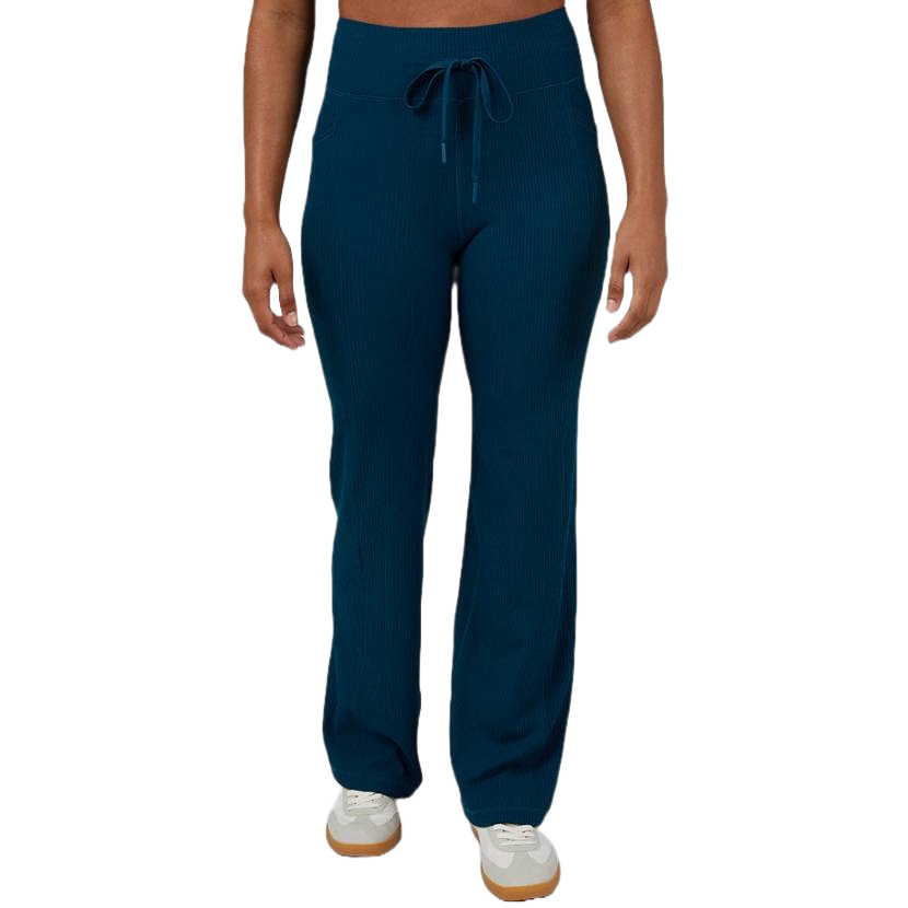 The 32 Degrees Active Flare Pants are a dark blue, ribbed fabric with a drawstring waist. They have a flared leg design and are paired with white sneakers.