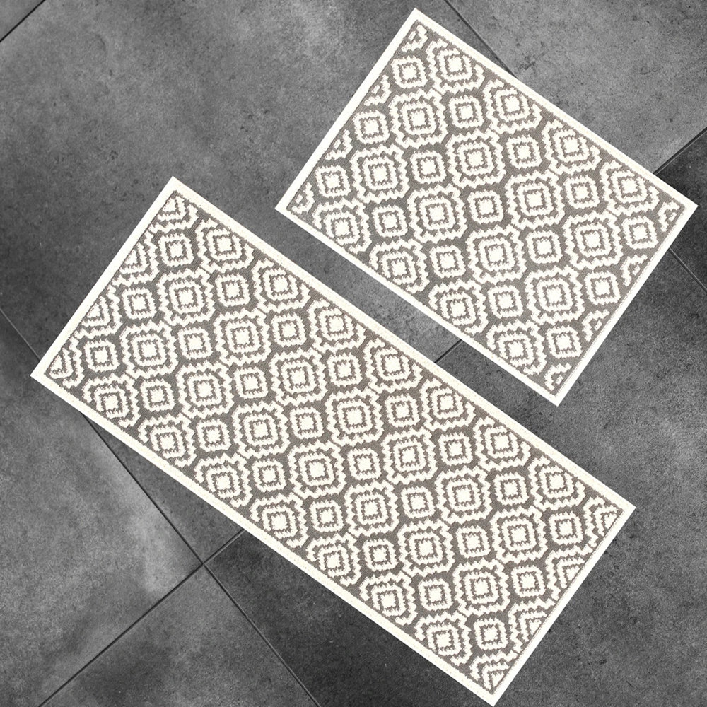 Two non-slip bath mats with a geometric pattern and a contrasting border.