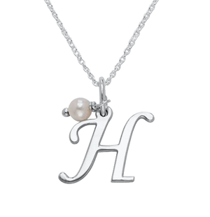 A silver necklace features a pendant in the shape of the letter \“H\“ accompanied by a small pearl charm.