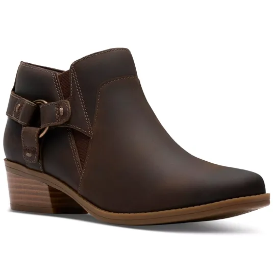 A brown ankle boot with a low stacked heel and decorative buckle strap on the side, featuring a smooth leather finish and subtle stitching accents.