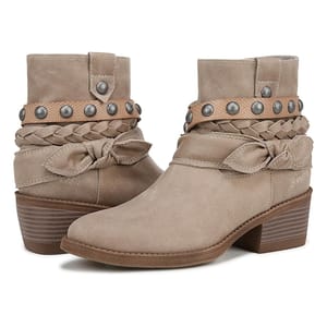 Blowfish Rally Booties are ankle-high boots in a beige suede material, featuring braided and knotted straps around the ankle, metal stud embellishments, and a low stacked heel.