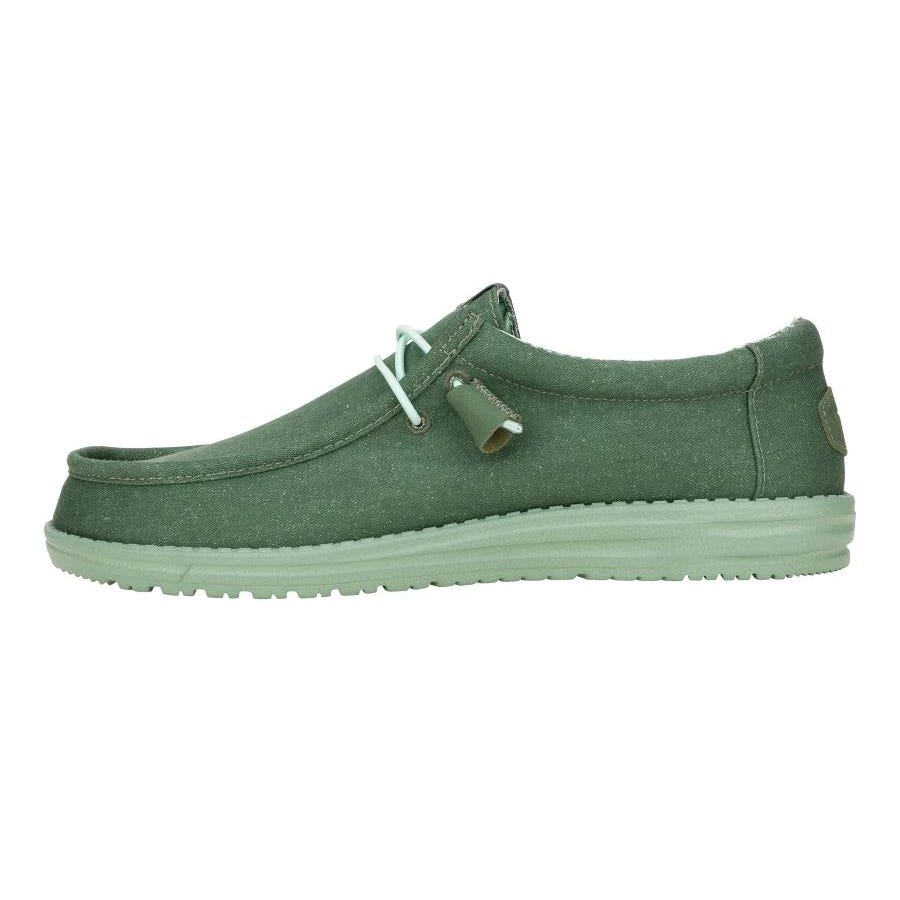 A green, casual slip-on shoe with a moccasin-style design featuring white laces and a subtle textured finish on the upper and sole.