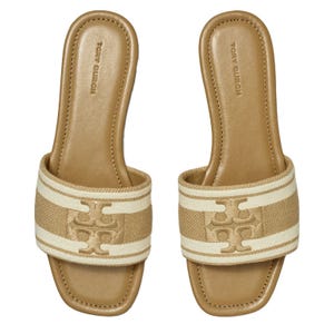 Tan slide sandals with a cushioned footbed, featuring a textured strap with the Tory Burch Double T logo in a lighter shade.