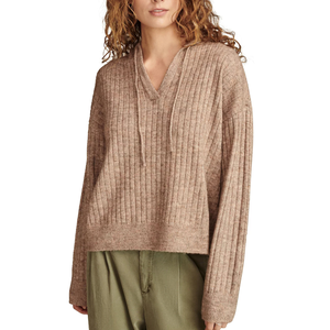 A woman is wearing a ribbed, brown V-neck sweater with a drawstring and long sleeves, paired with olive green pants.