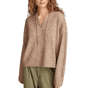 A woman is wearing a ribbed, brown V-neck sweater with a drawstring and long sleeves, paired with olive green pants.