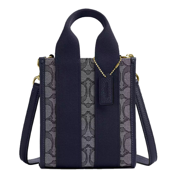 A compact handbag with a navy-blue color scheme, featuring a patterned fabric on the front, wide handles, a detachable shoulder strap, and gold hardware.