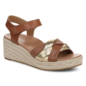 A wedge sandal featuring braided brown and gold straps, an ankle strap, and a woven espadrille-style platform sole.