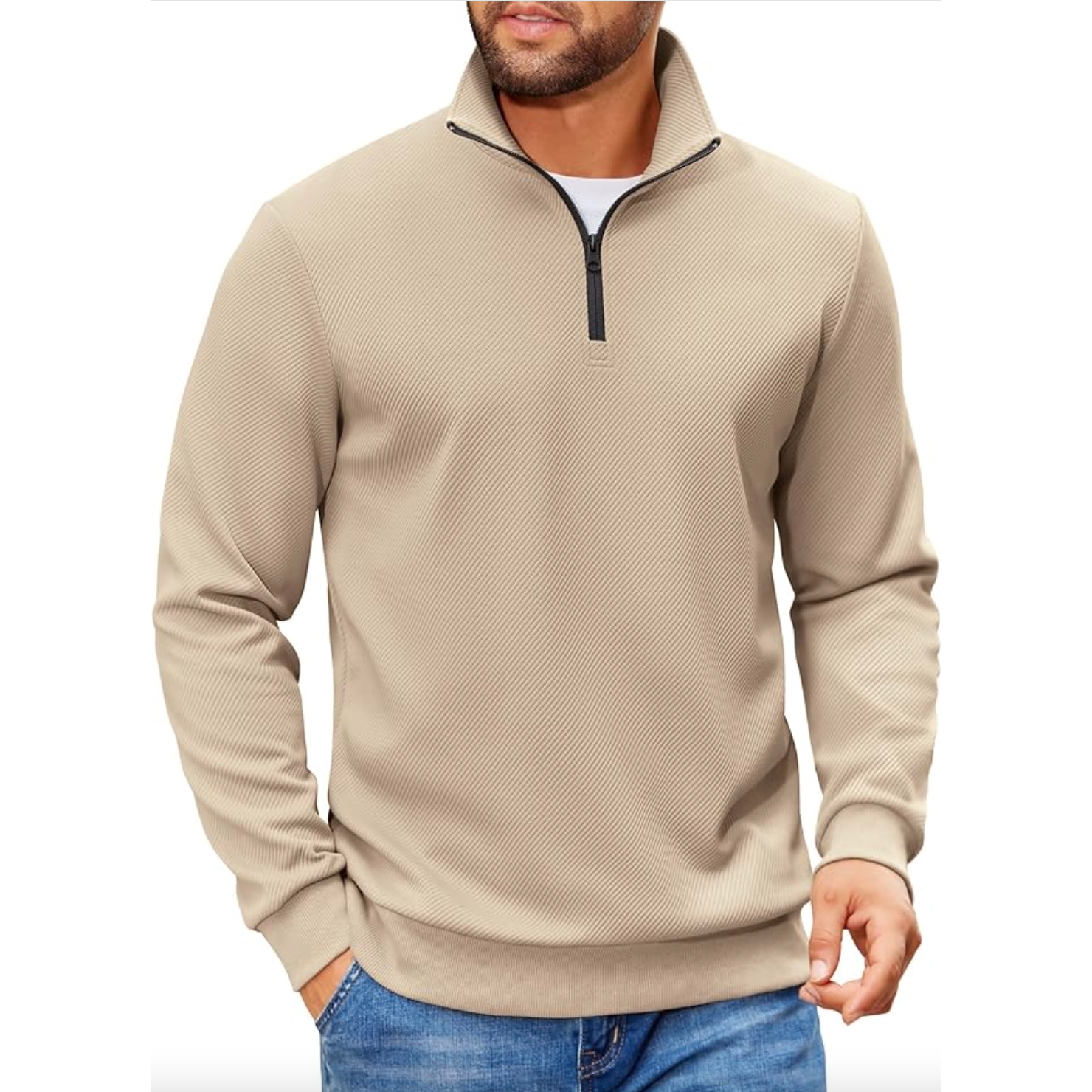 A beige, long-sleeve, quarter-zip pullover paired with blue jeans, featuring a textured fabric and a black zipper, worn over a white undershirt.