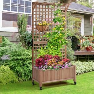 Wooden planter box with a trellis and wheels, featuring climbing yellow flowers, pink and red blooms, and a hanging basket.