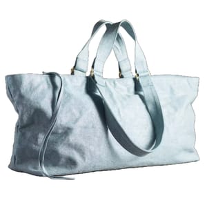 Light blue denim duffel bag with dual handles and a shoulder strap, featuring gold-tone hardware.