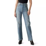 A person is wearing high-waisted, light blue straight-leg jeans paired with a black top and black shoes.