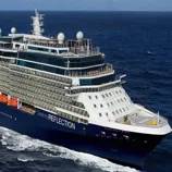 A large cruise ship named Celebrity Reflection is sailing on the ocean, featuring multiple decks, balconies, and visible lifeboats.