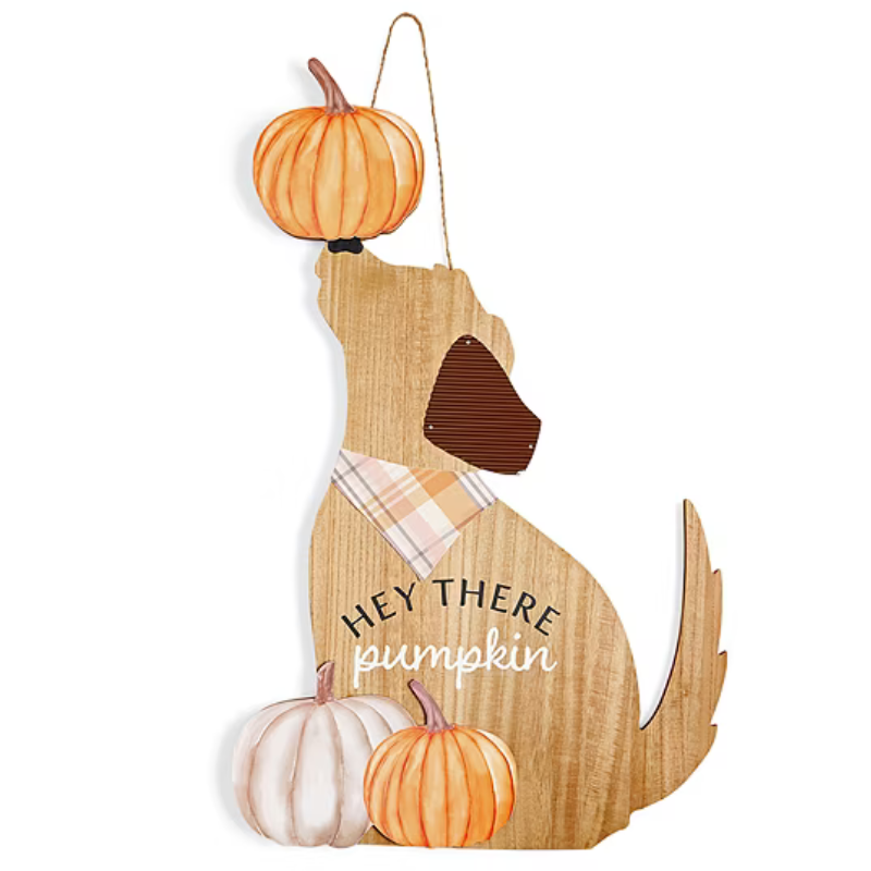 Wooden dog silhouette decoration featuring a plaid bandana, an orange pumpkin balanced on the nose, and two pumpkins at the base. Text reads \“Hey there pumpkin.\“