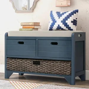 Blue storage bench with a cushioned seat, featuring two upper drawers and a woven basket in the lower section. A blue-white patterned pillow and stacked books are on top.